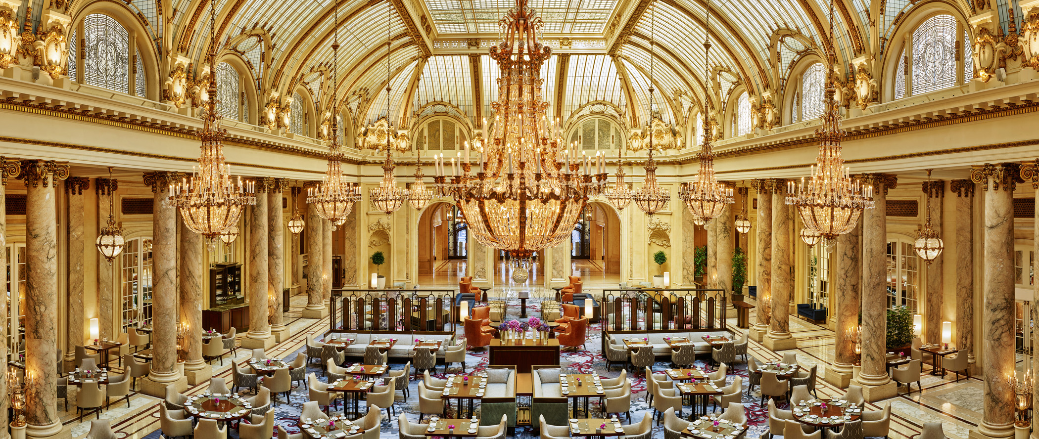 a large room with tables and chairs and chandeliers