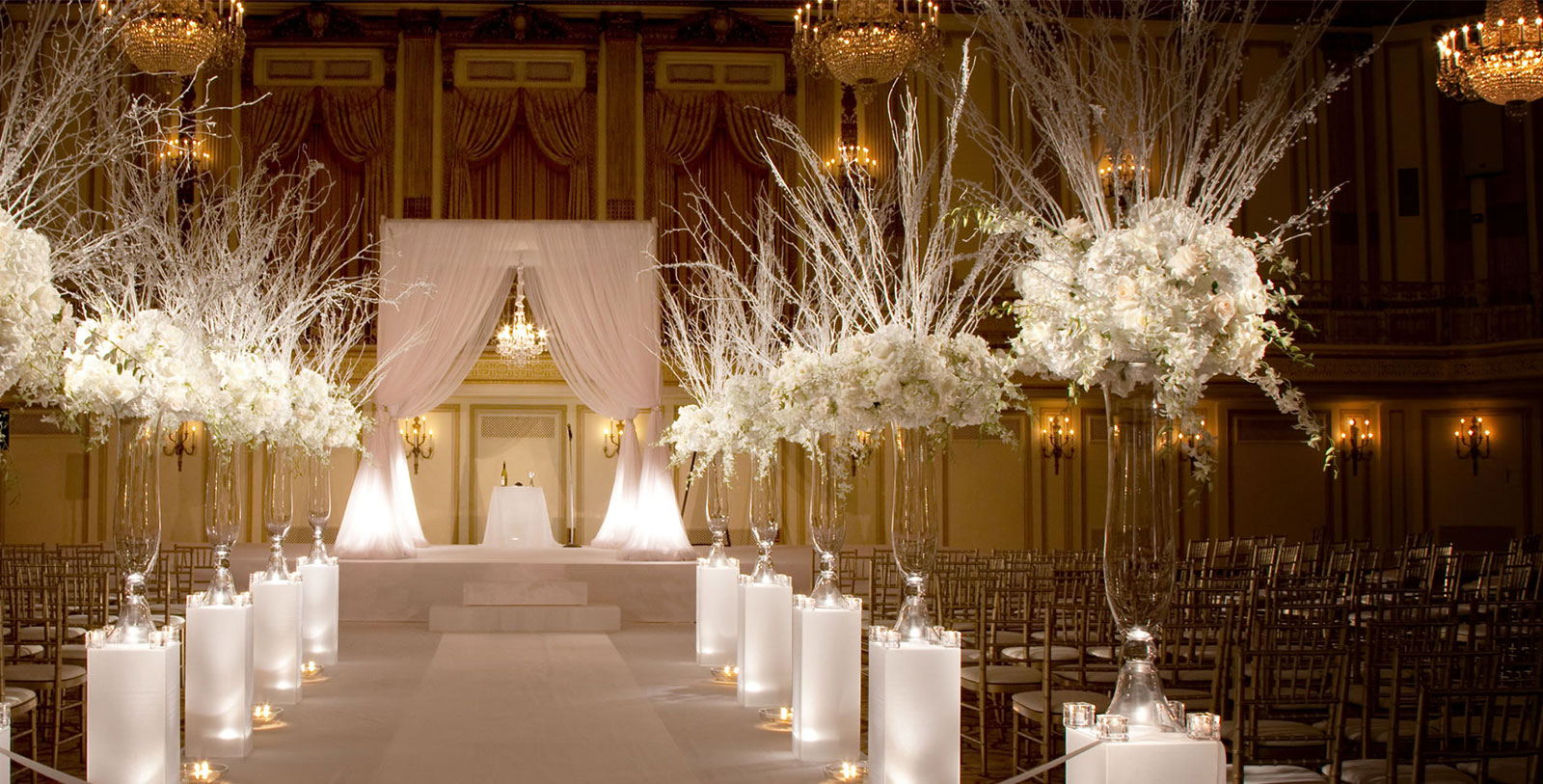 a wedding ceremony with white flowers and candles