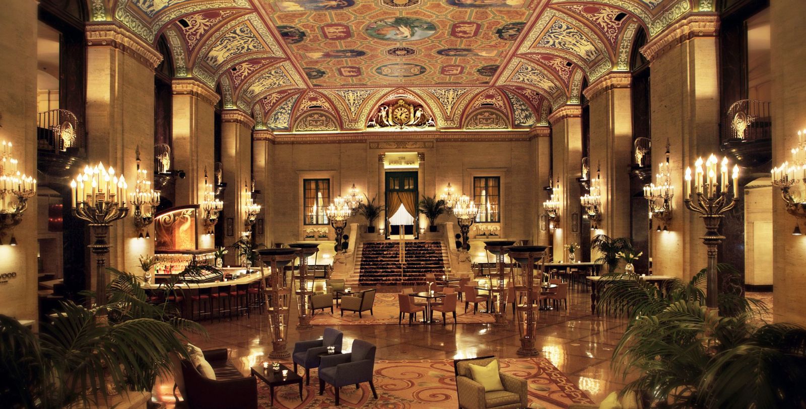 a large room with a large staircase and chandeliers with The Palmer House Hilton in the background