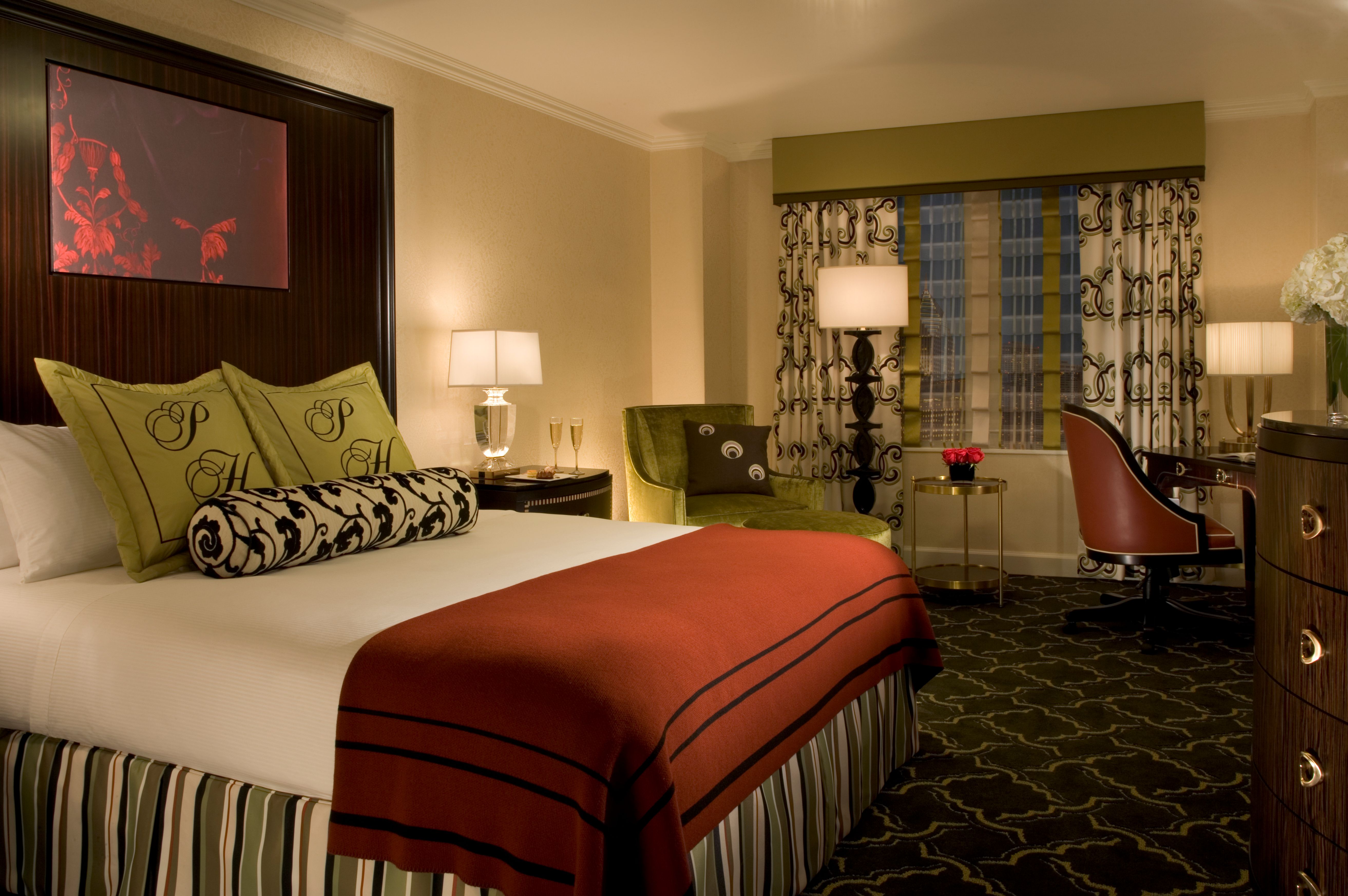 a room with a bed and chairs