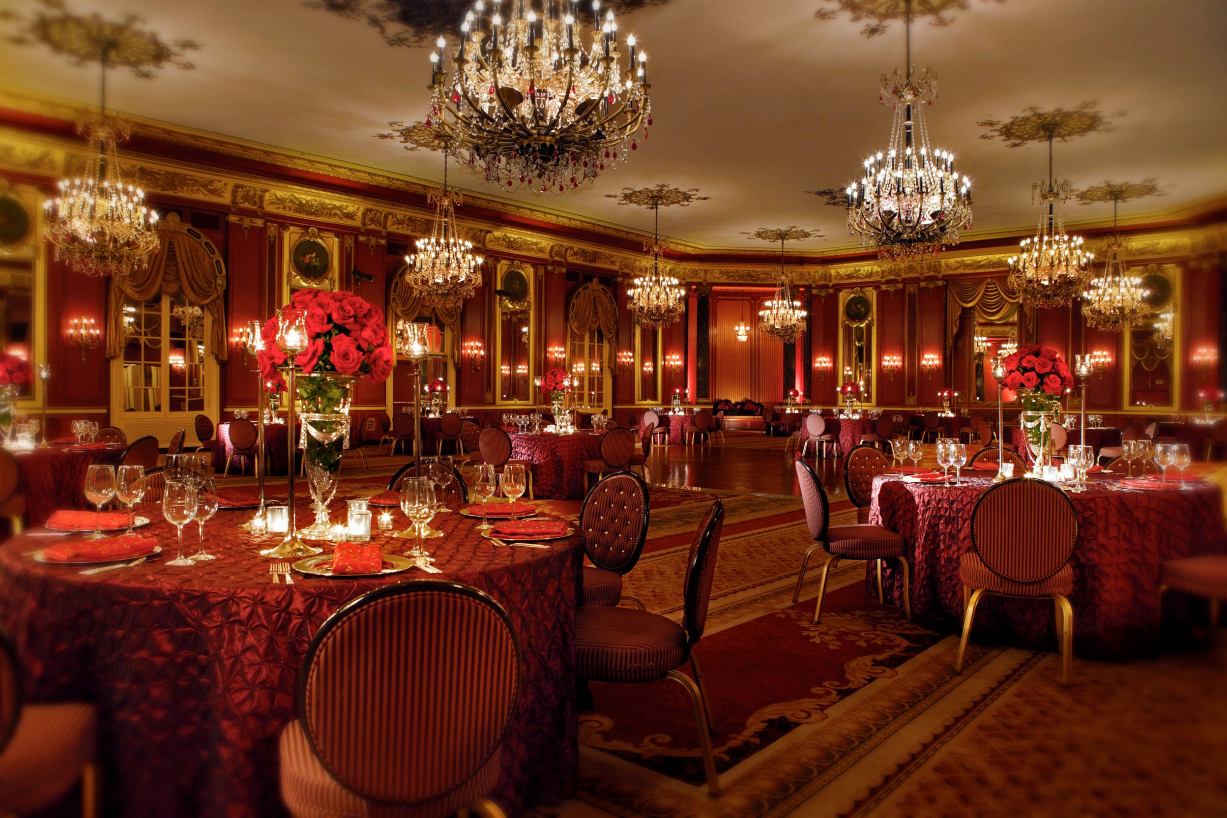 a room with tables and chairs and chandeliers