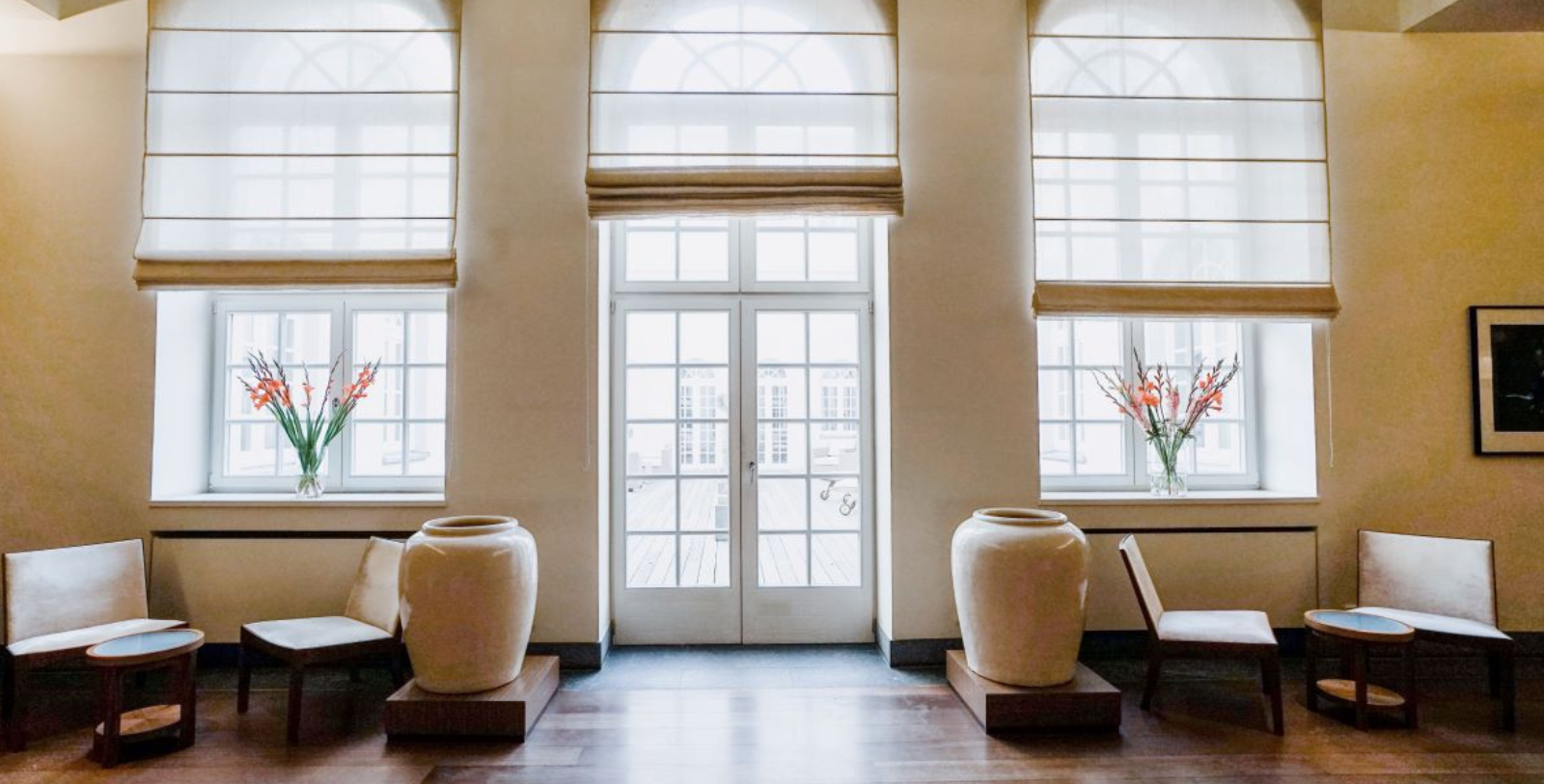 a room with large white vases and windows