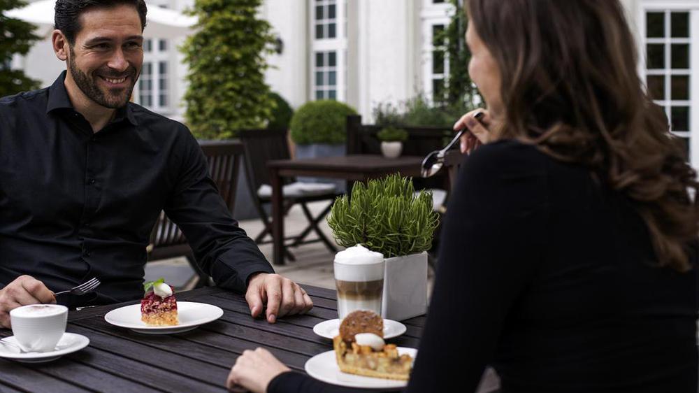 a man and woman sitting at a table with food on plates