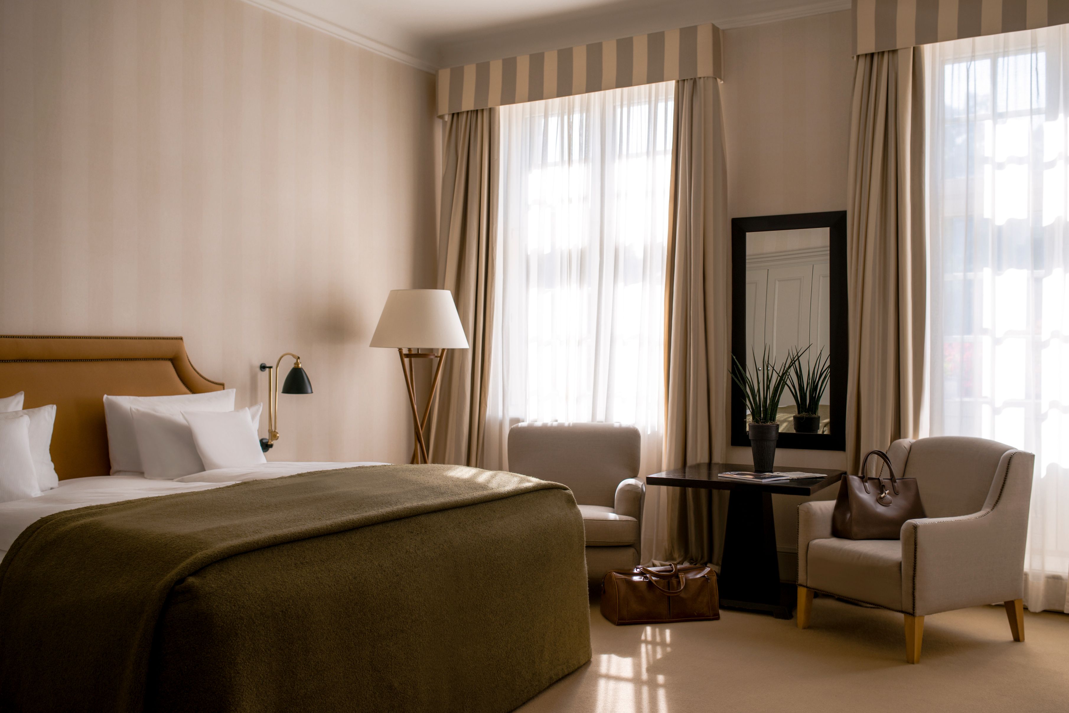 a room with a bed and chairs