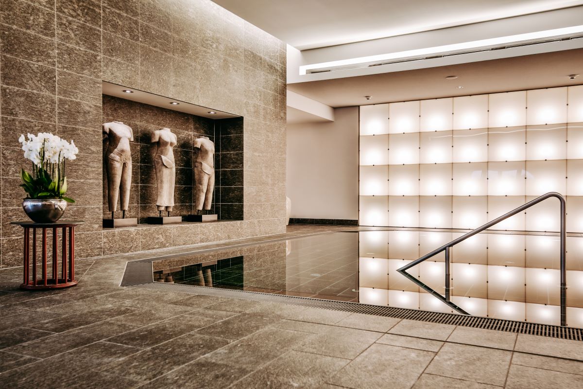 a room with a pool and statues