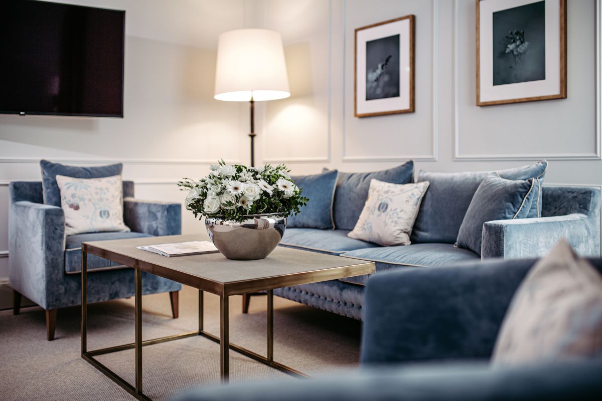 a living room with a couch and a vase of flowers