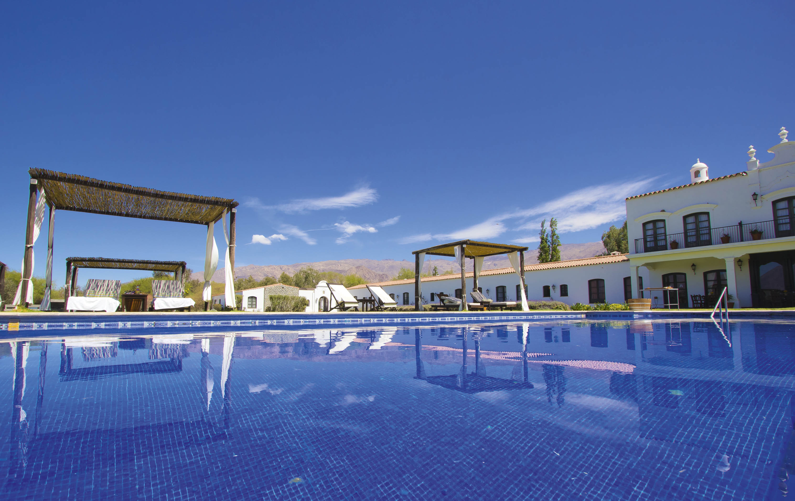 a pool with a white building and a blue sky