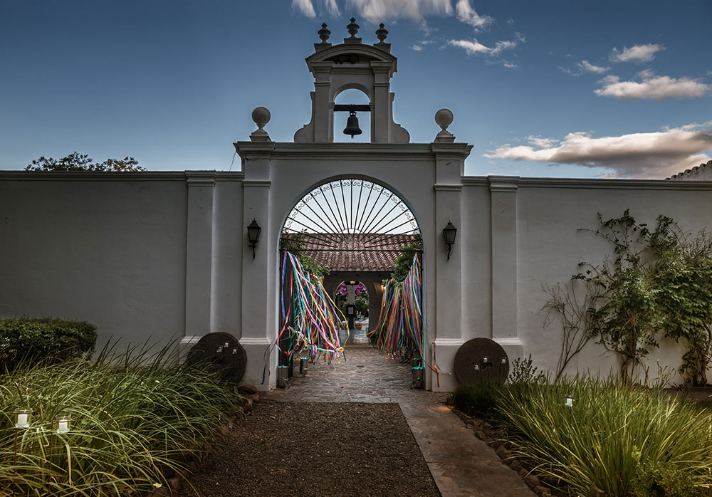 a white wall with a bell and colorful ribbons
