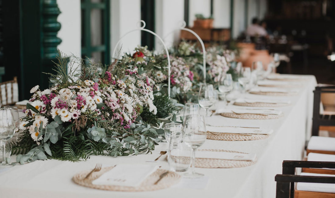 a long table with flowers and glasses