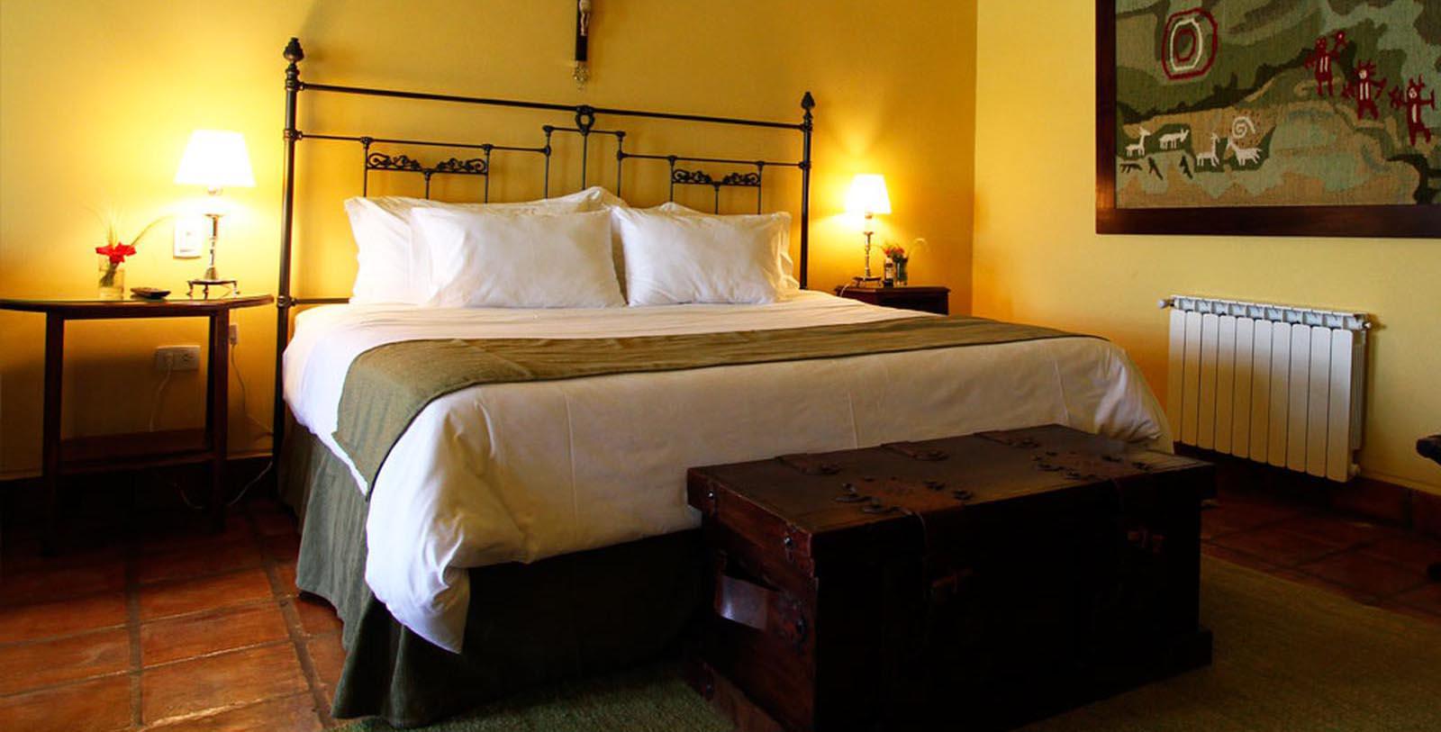 a bed with a trunk and lamp