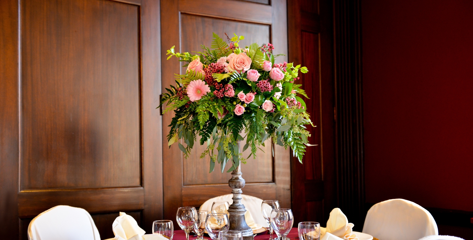 a table with a vase of flowers and glasses