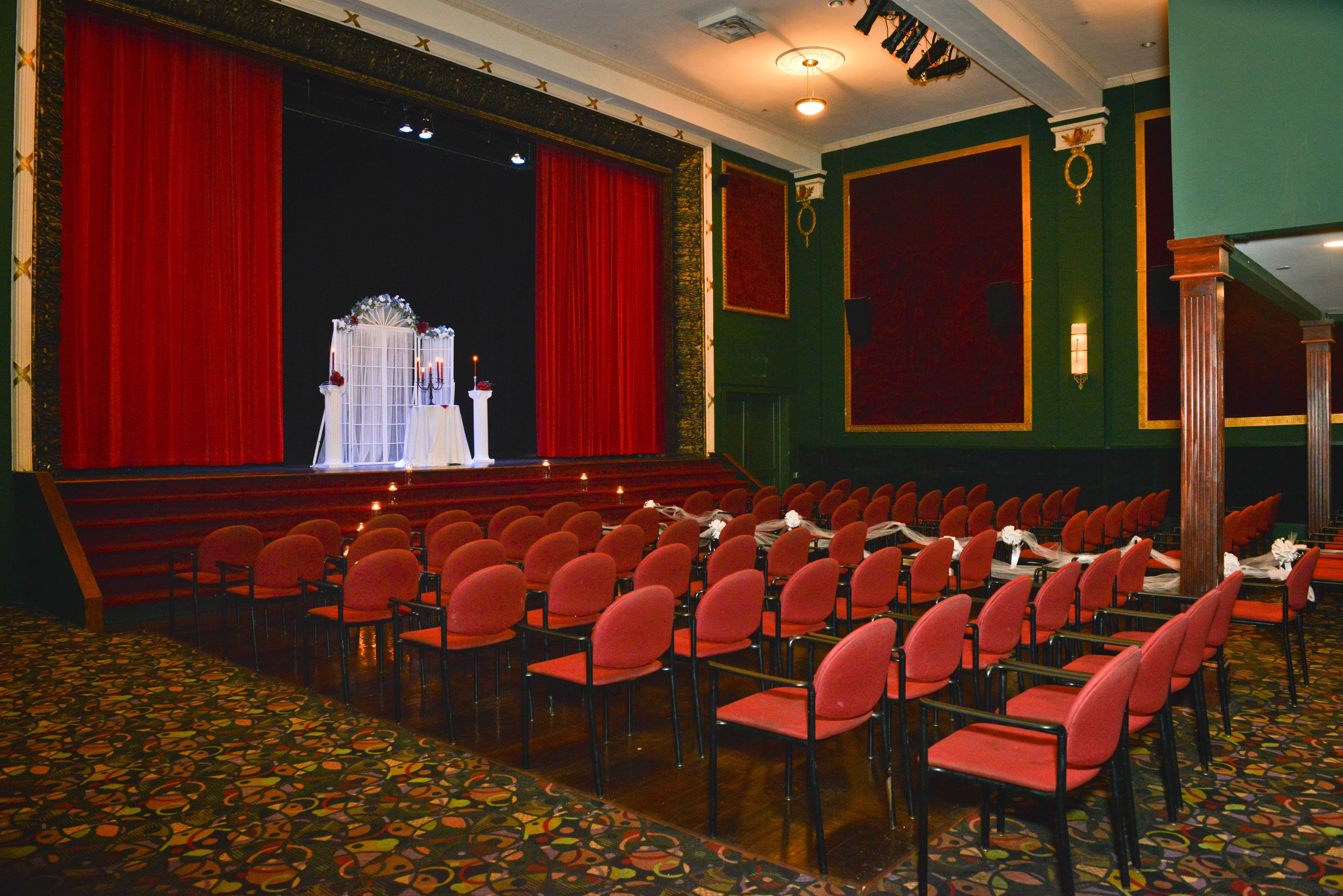 a room with red chairs and a stage