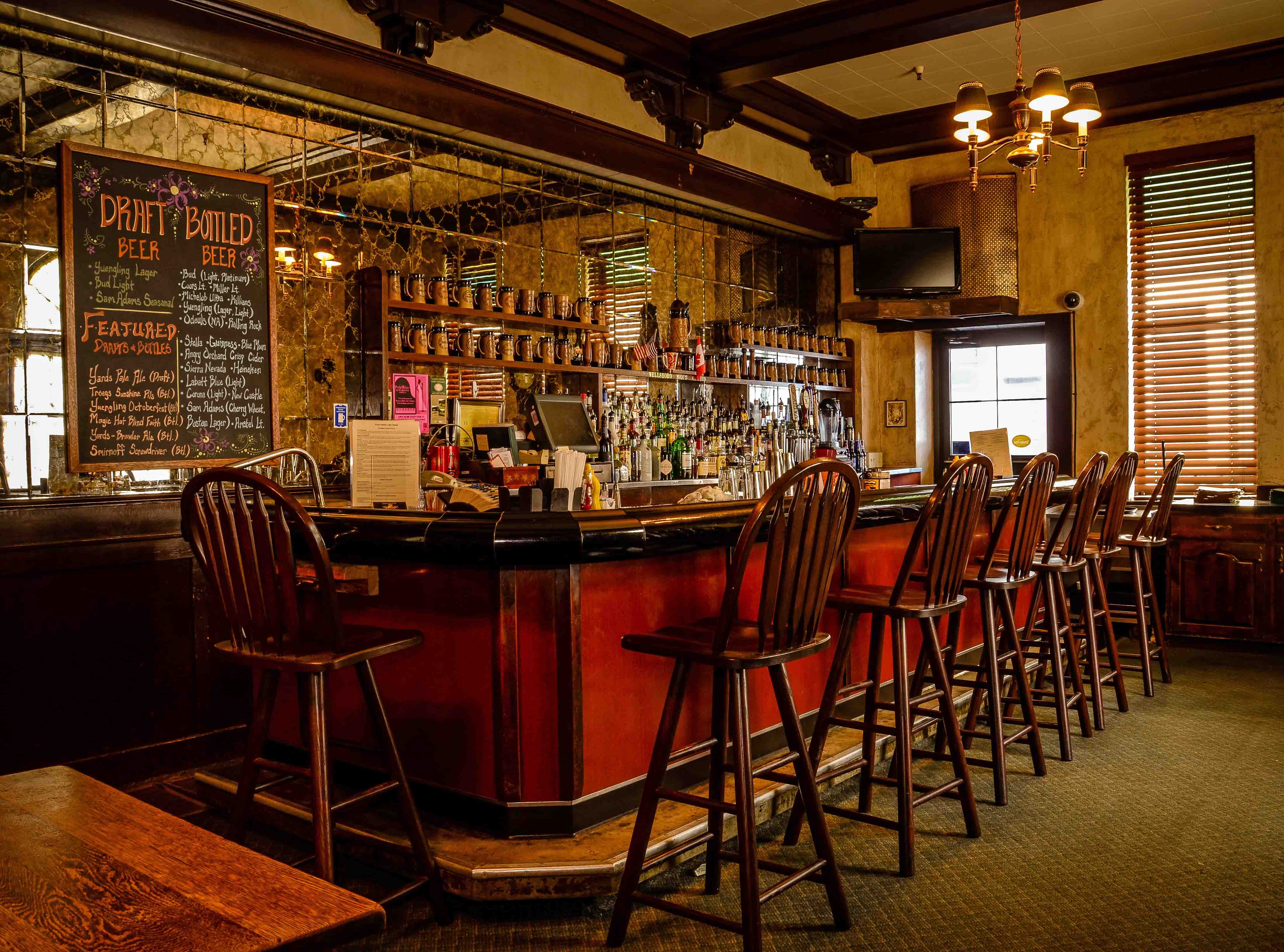 a bar with chairs and a black board