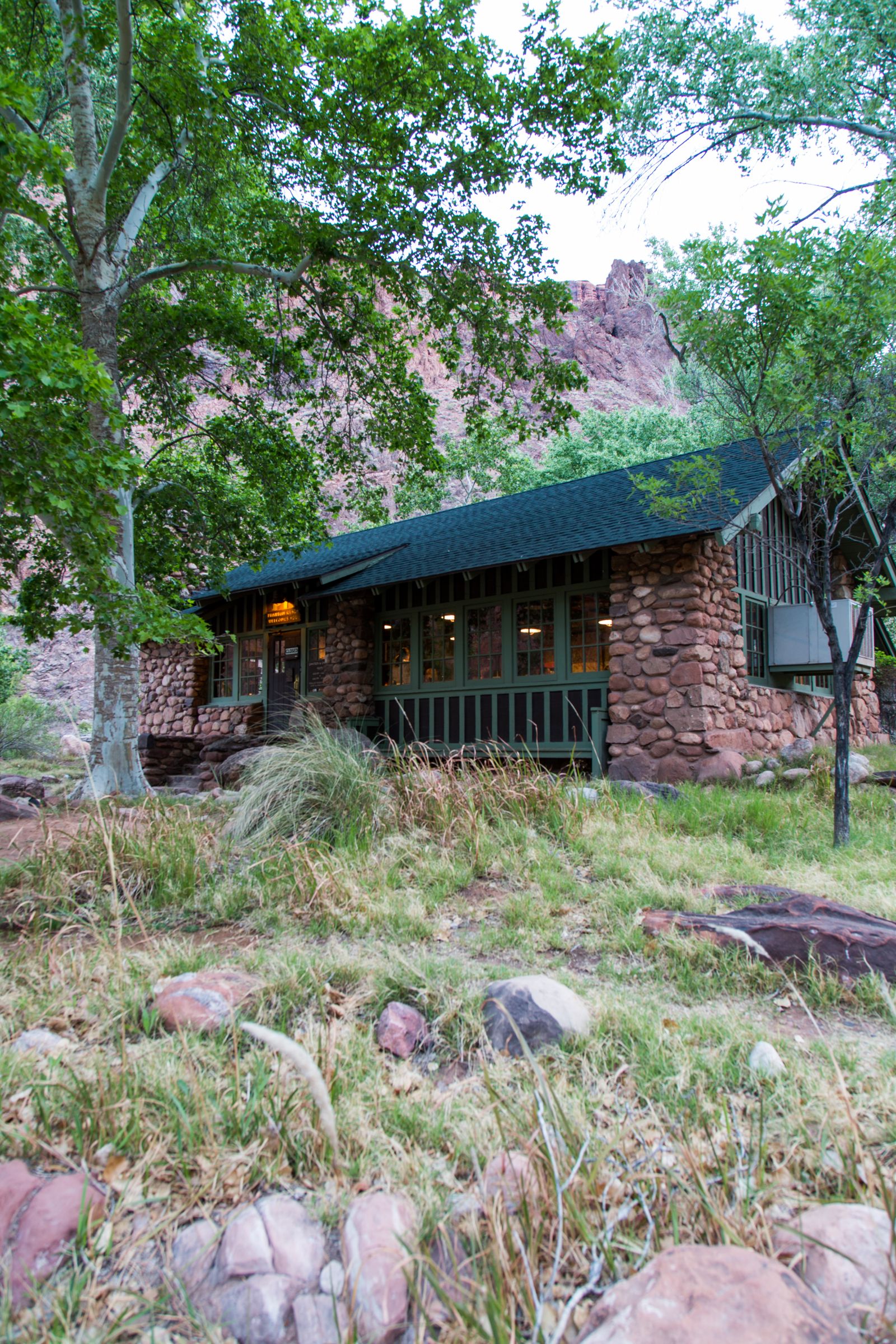 a stone building with trees and grass