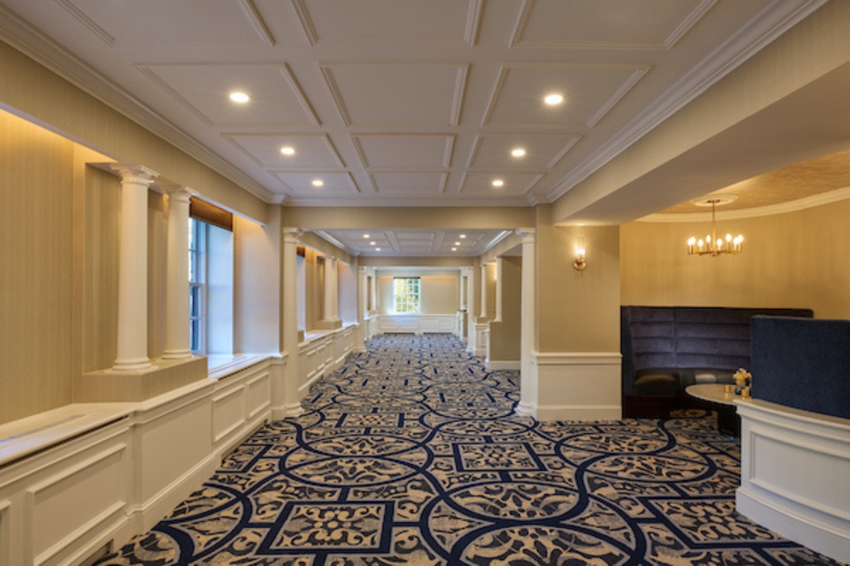 a long hallway with blue and white carpet