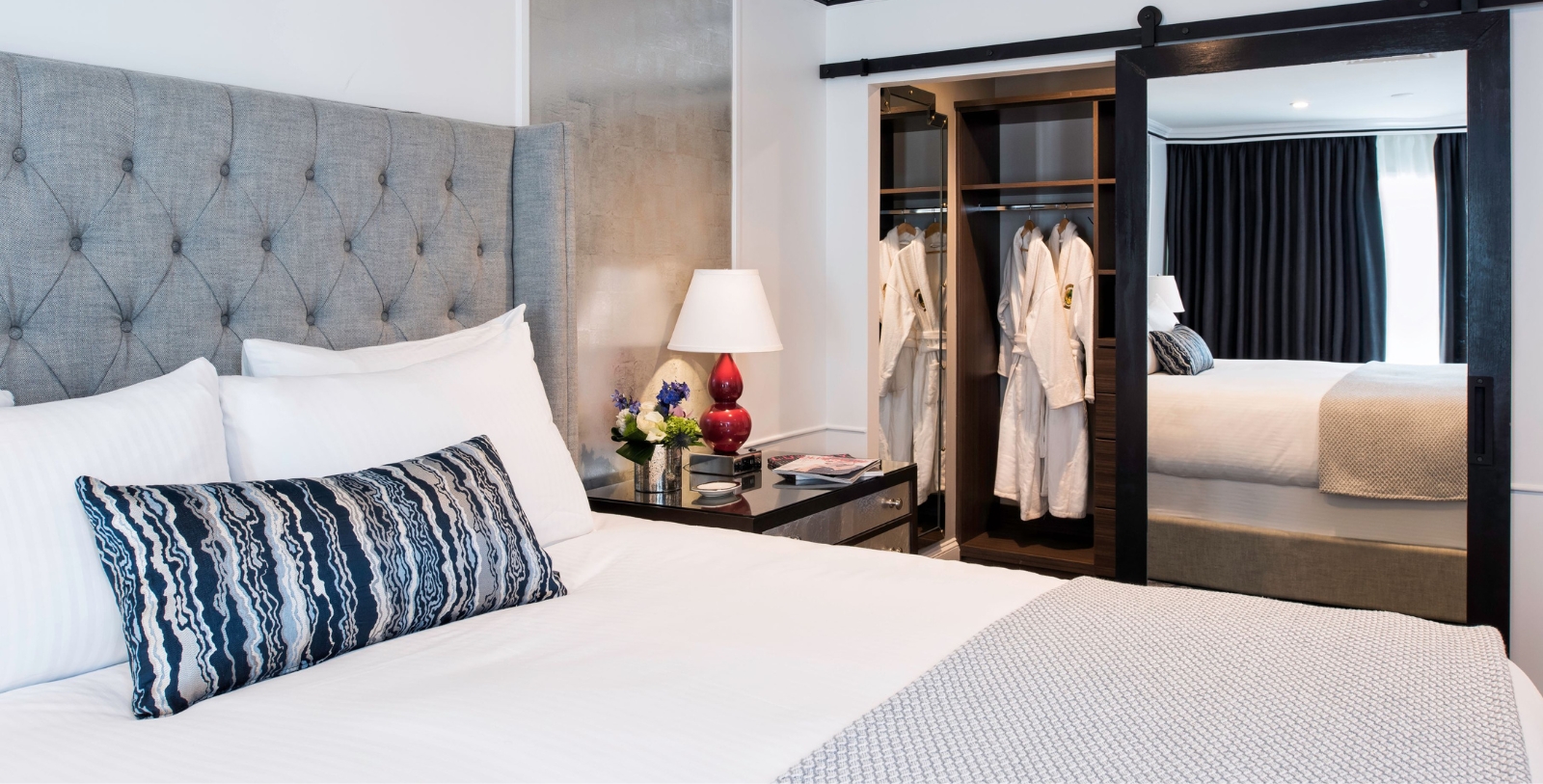 a bedroom with a mirror and a bed