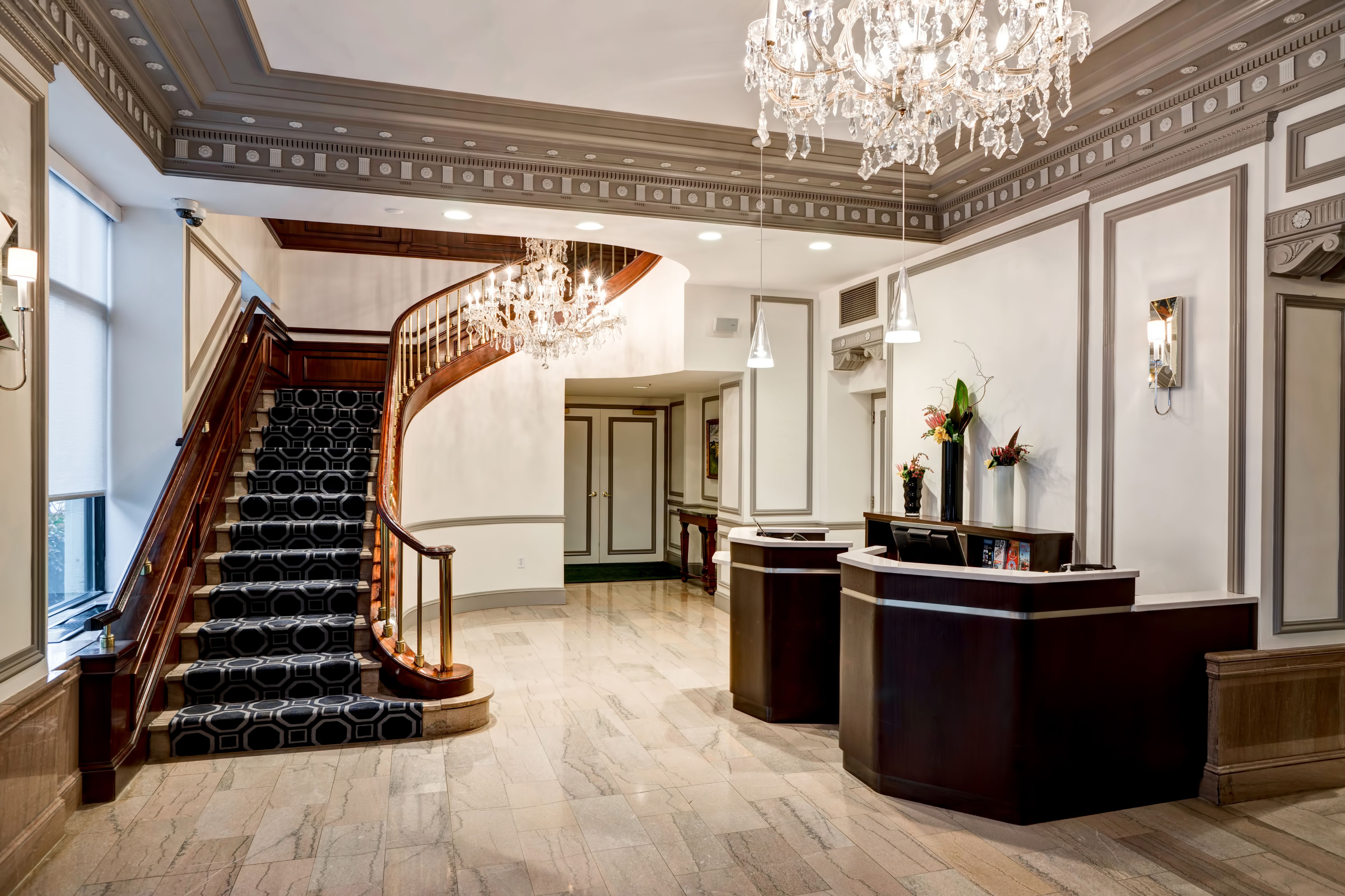 a lobby with a staircase and chandelier