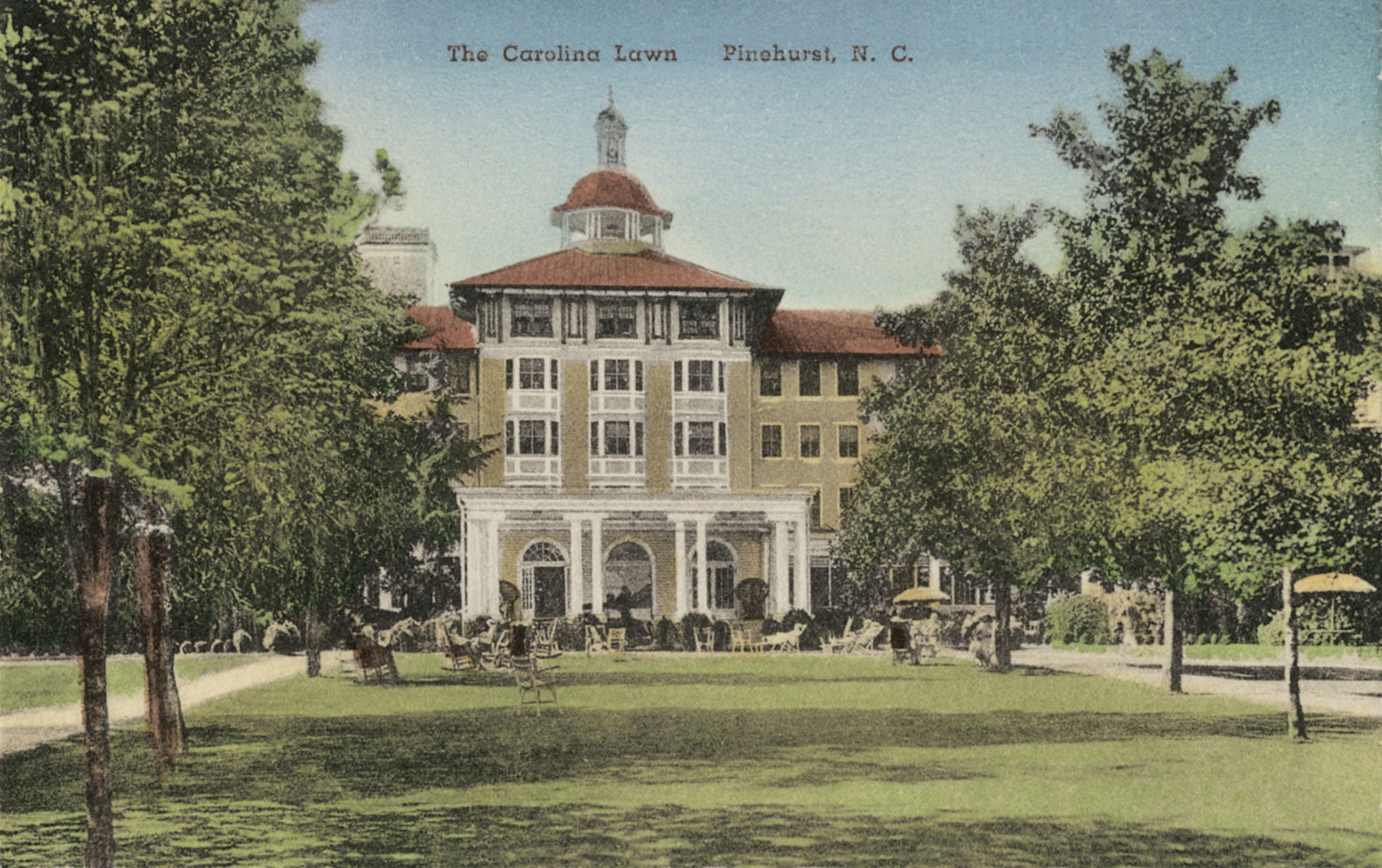 a large building with a lawn and people in the front