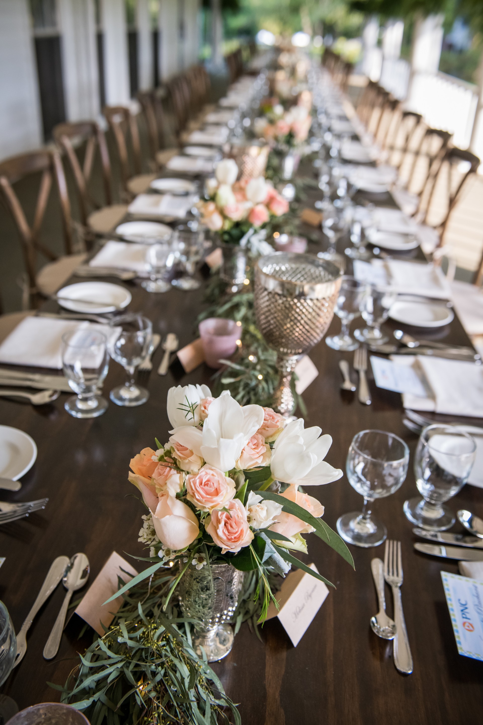 a long table with flowers and glasses