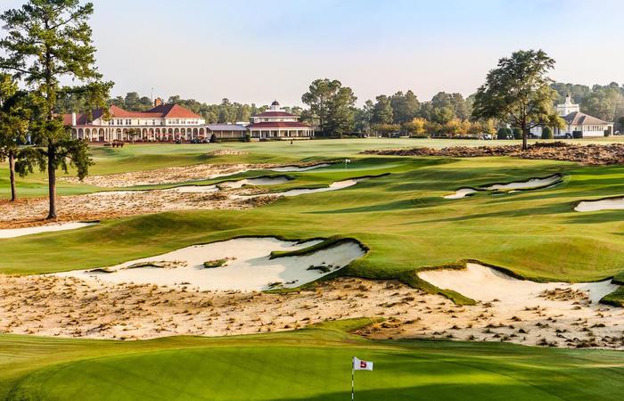 a golf course with a building and sand bunkers