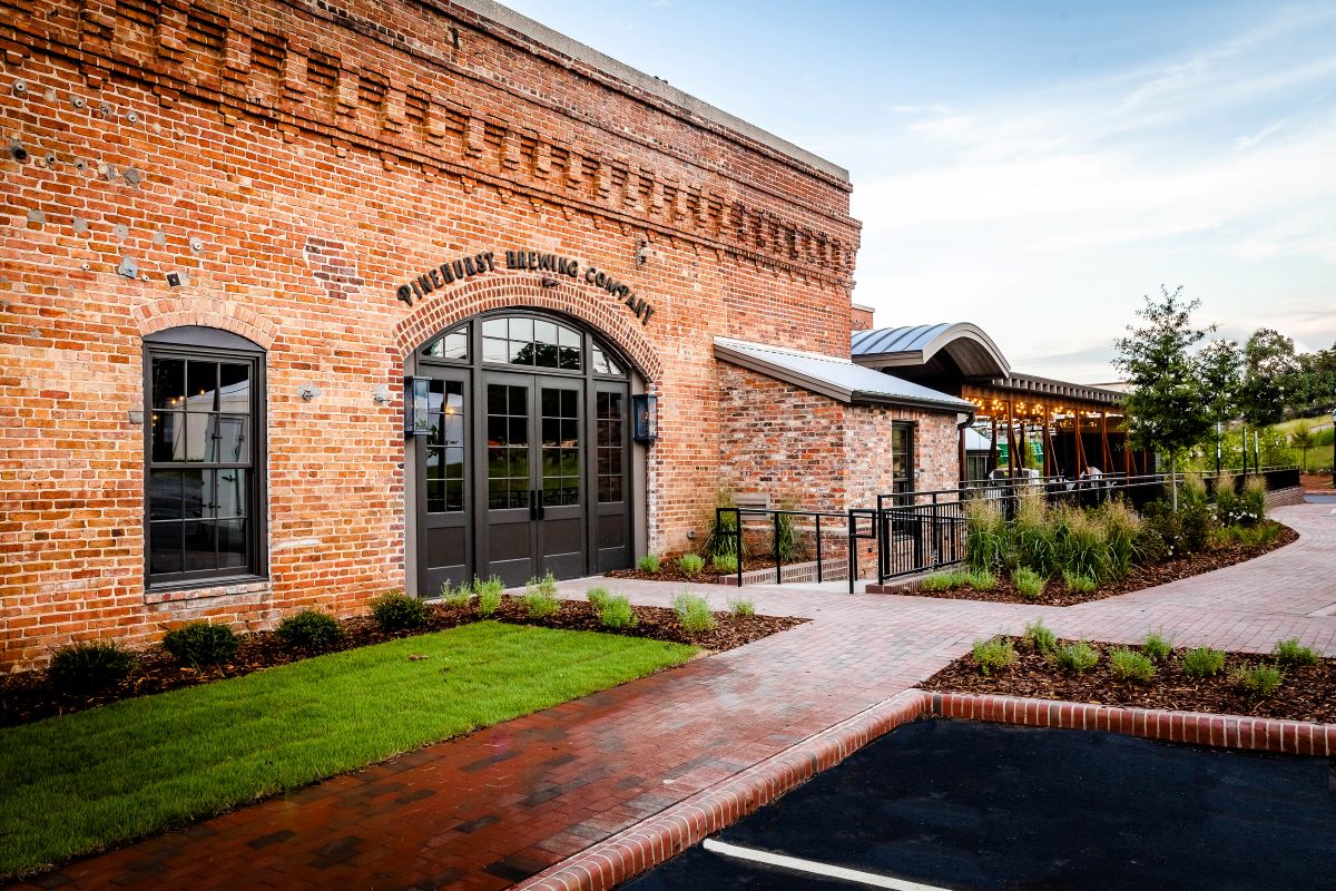 a brick building with a parking lot and a sidewalk