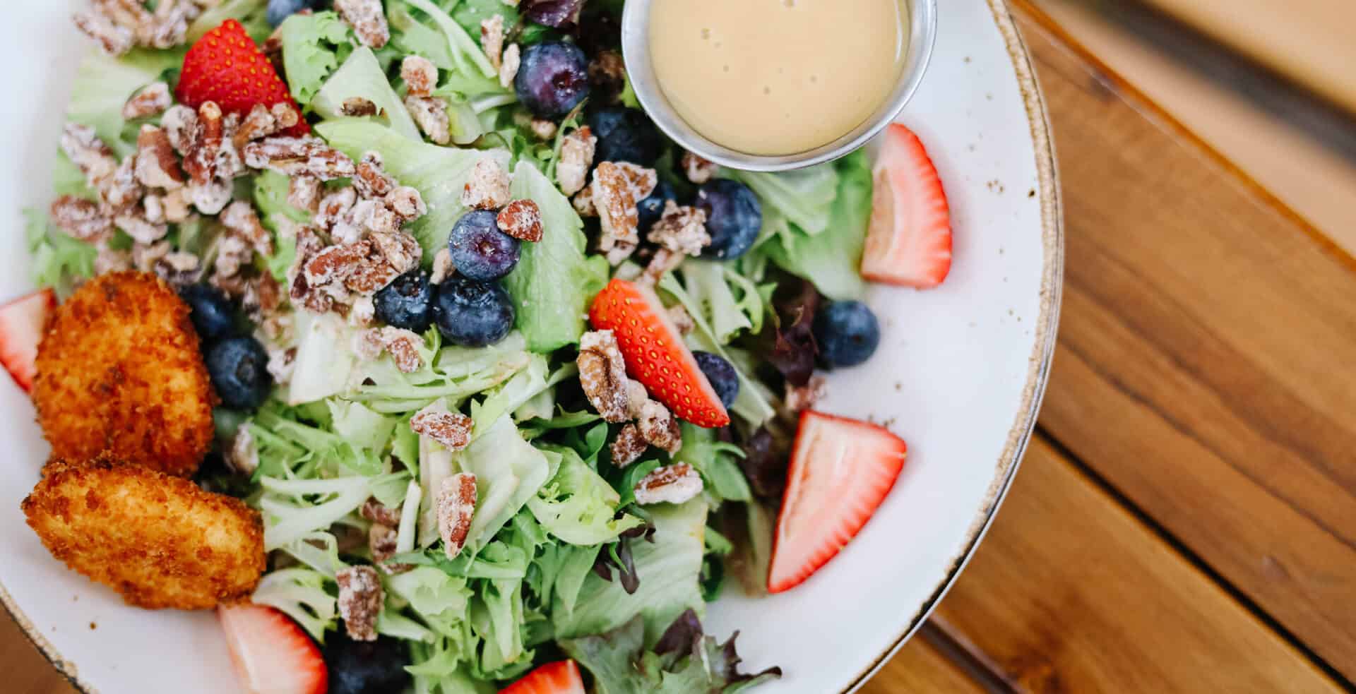 a salad with fruit and nuts on a plate
