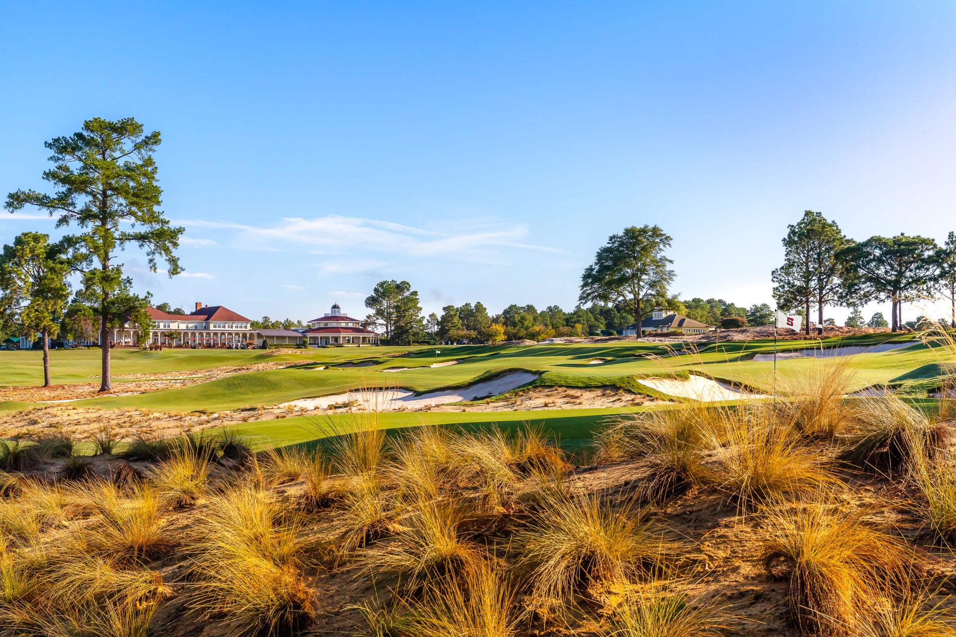 a golf course with a building and sand bunkers