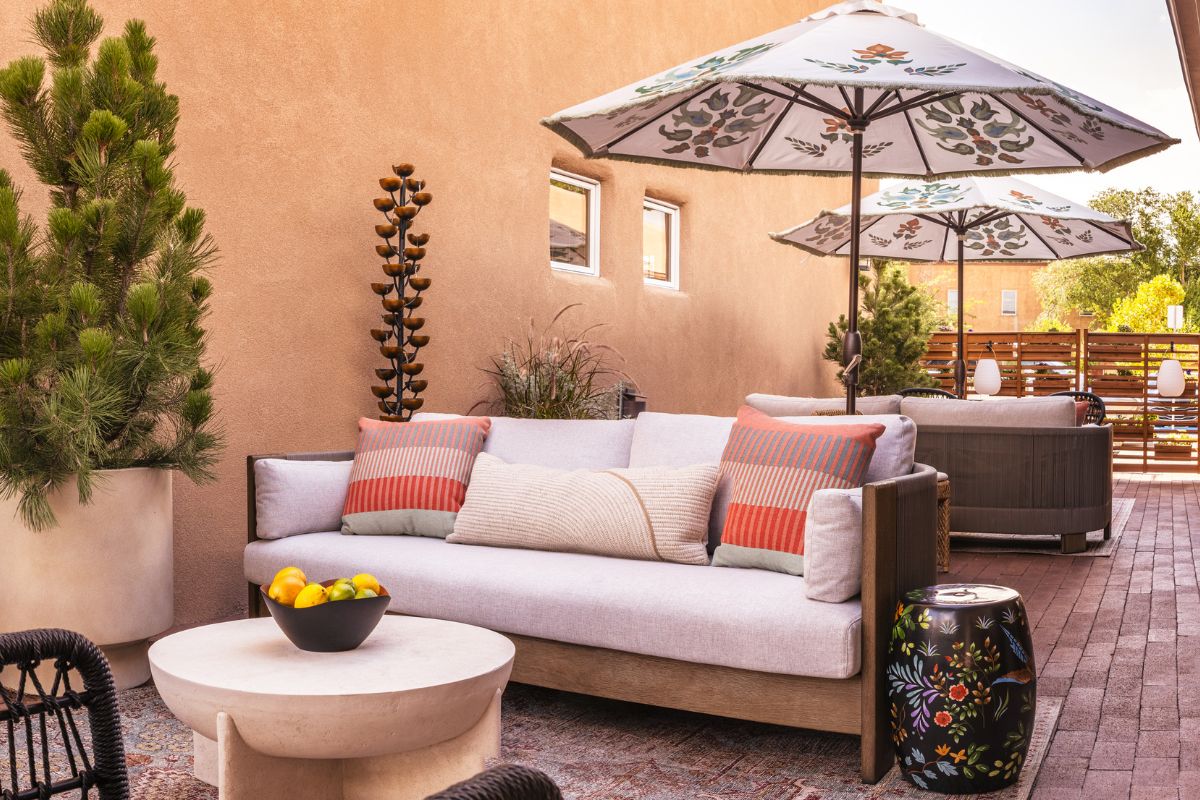 a patio with a couch and umbrella