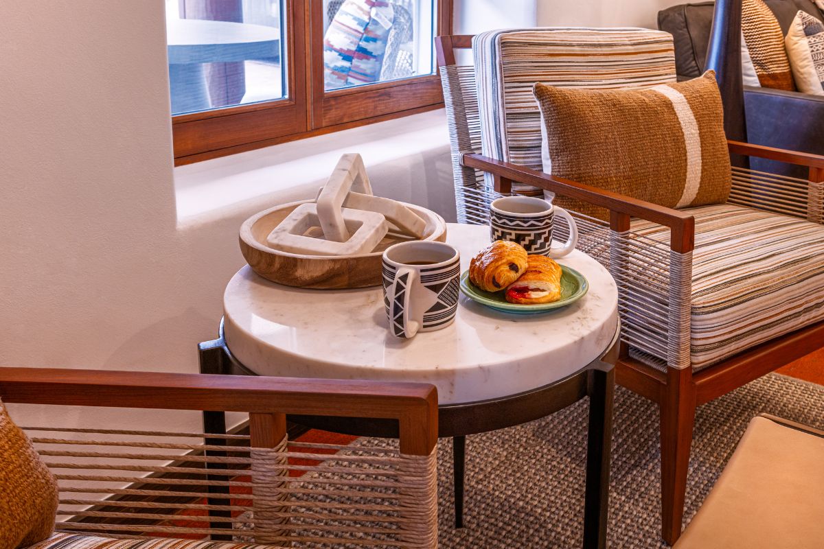 a table with a plate of pastries and cups on it