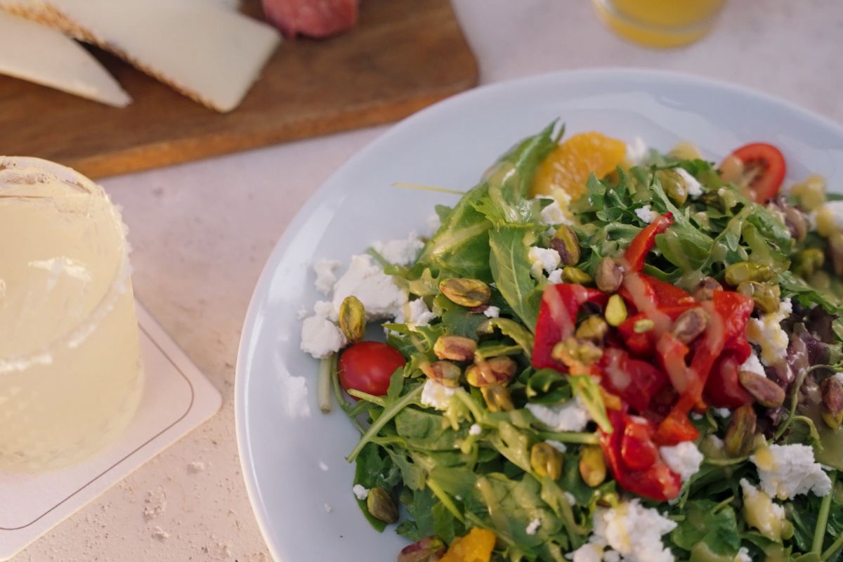 a plate of salad with tomatoes and cheese