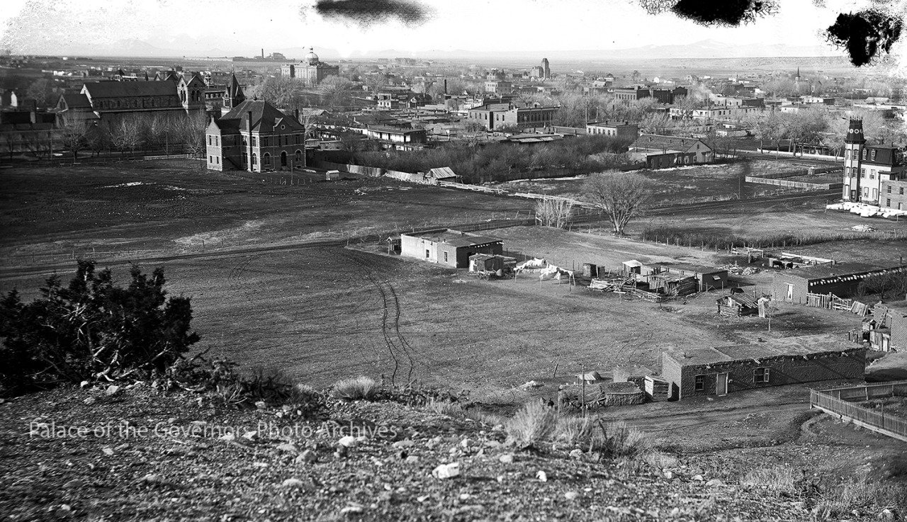 a large field with buildings in the background