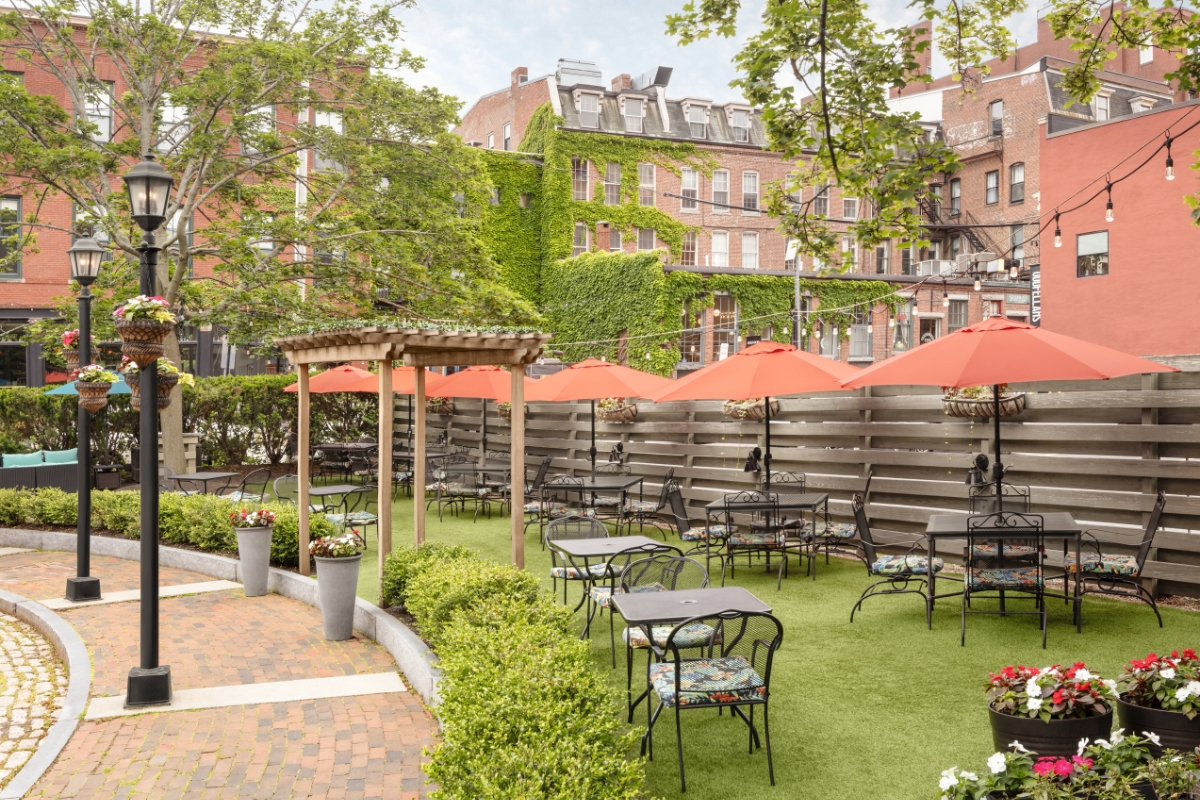 a patio area with tables and chairs and umbrellas