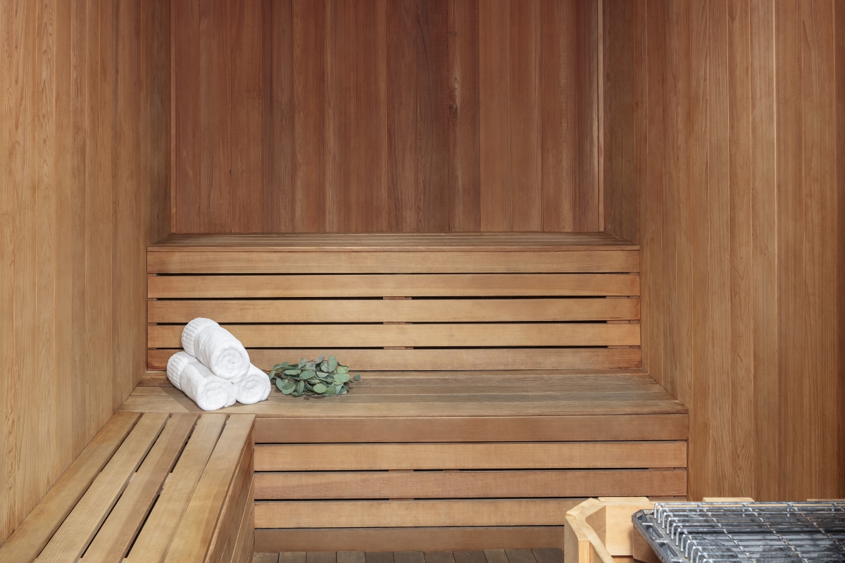 a wooden sauna with towels and a plant