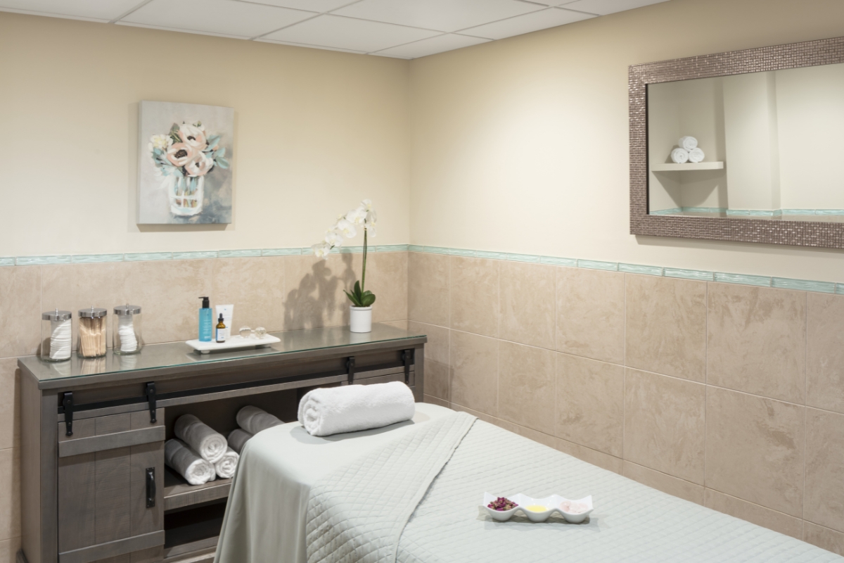 a massage room with a bed and towels