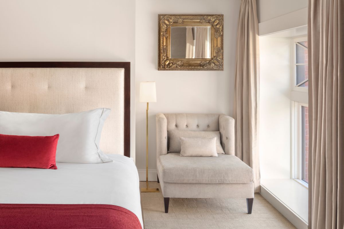 a bedroom with a bed and a chaise lounge