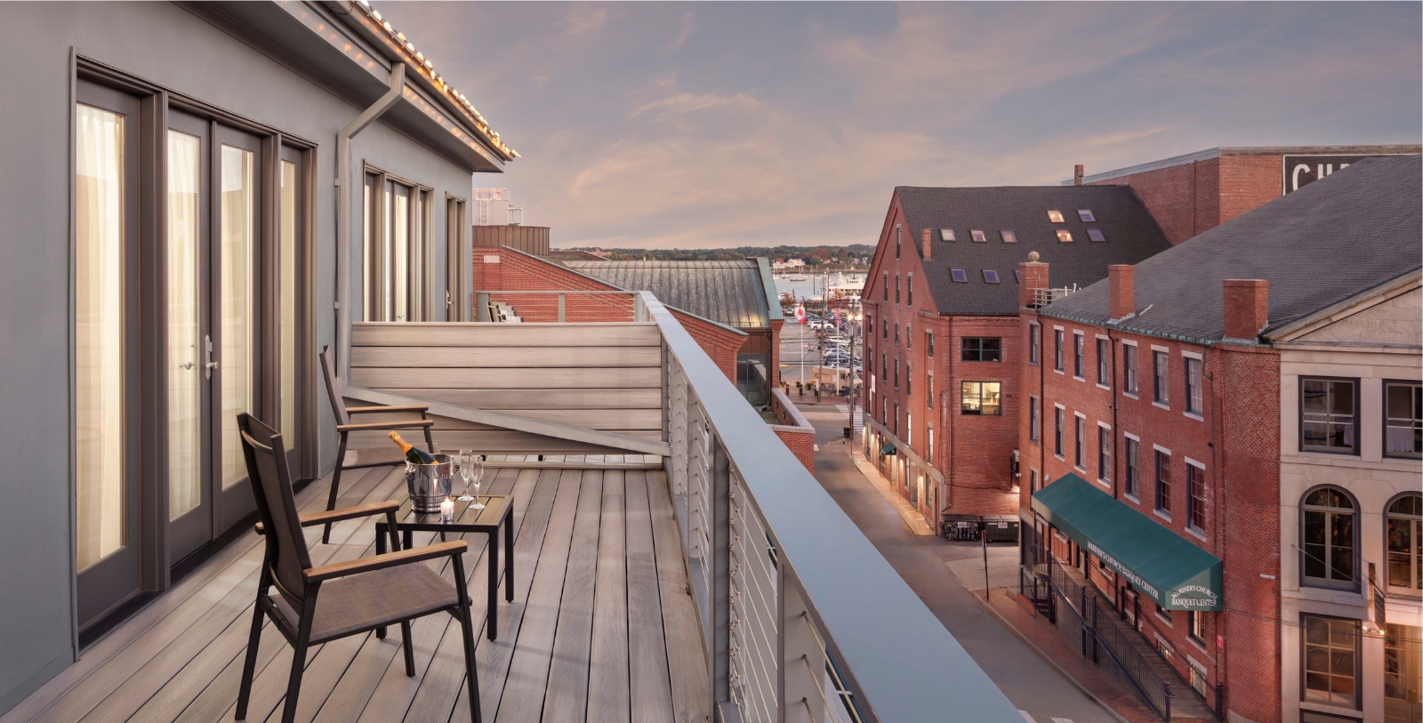 a deck with chairs and a bottle of wine on it