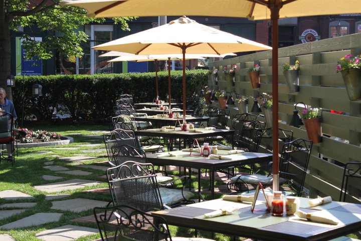 tables and chairs outside with umbrellas