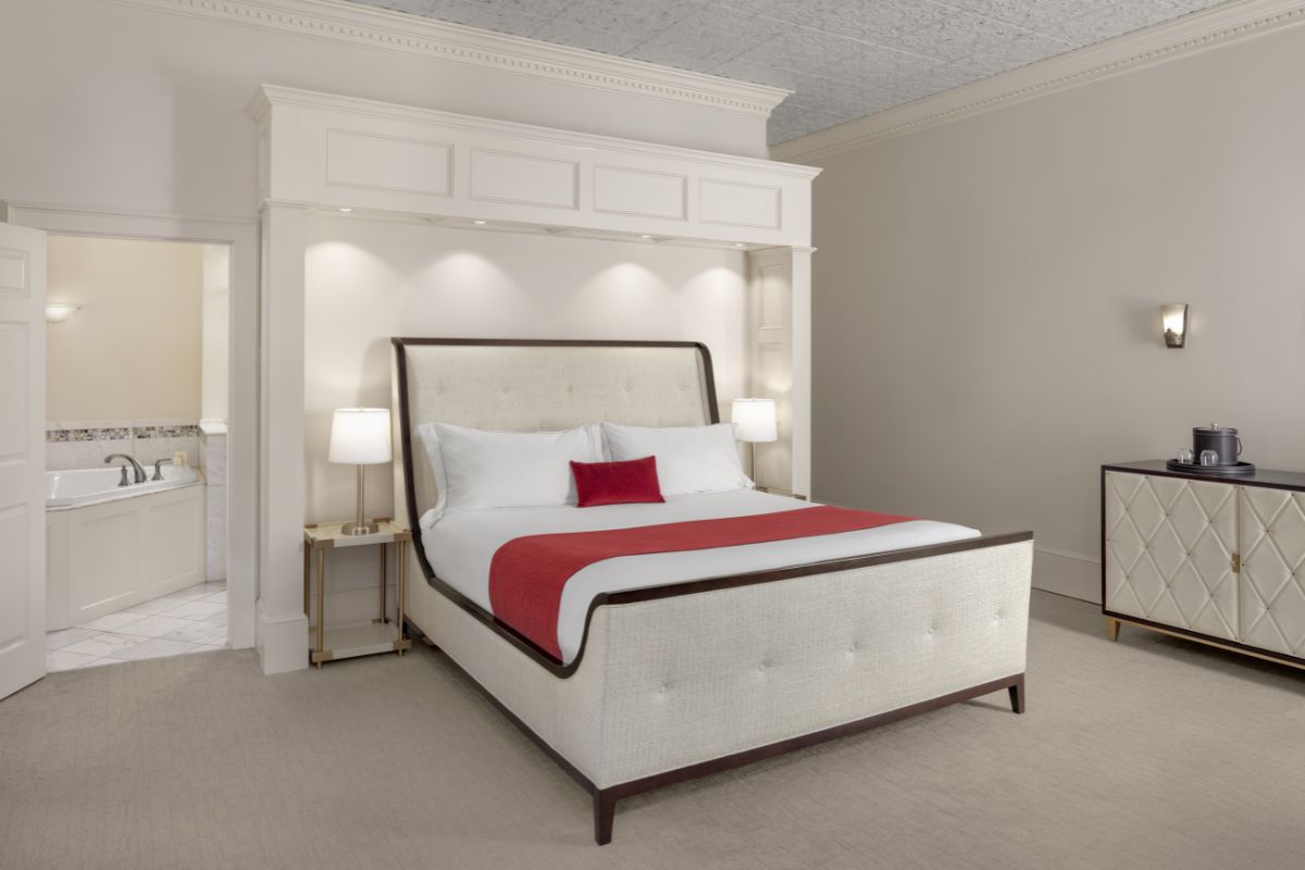 a bed with a red blanket and a white wall