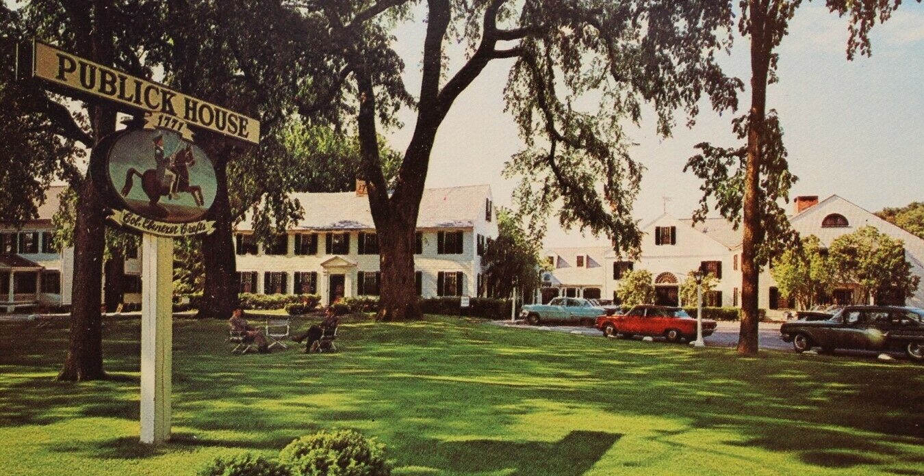 a house with a lawn and cars in front of it
