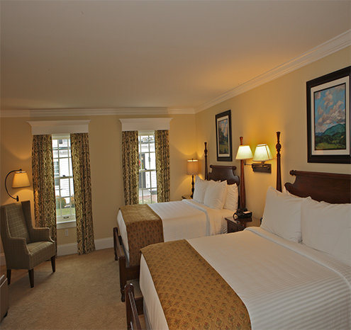a room with two beds and a chair