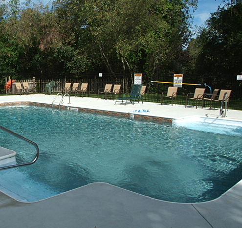 a pool with chairs and a fence