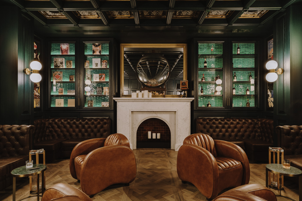 a room with leather chairs and fireplace