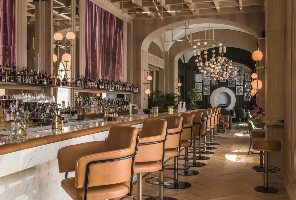 a bar with chairs and a chandelier