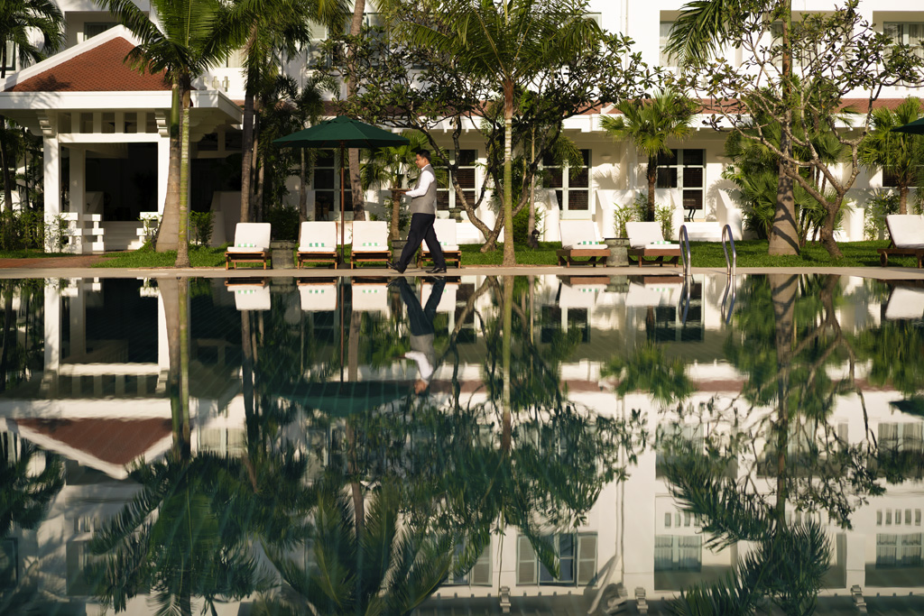 a man walking by a pool