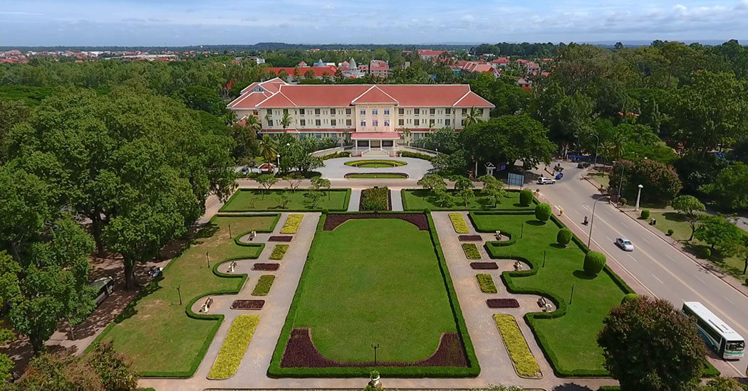 a large building with a lawn and trees
