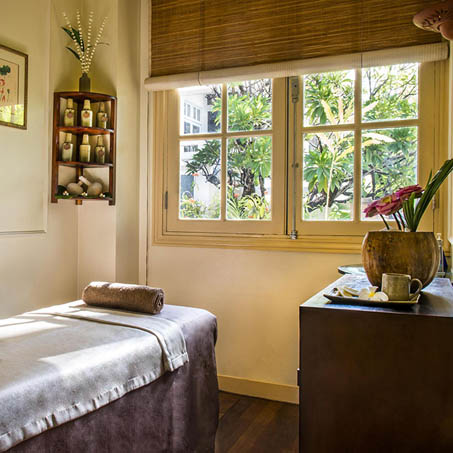 a room with a bed and a vase of flowers