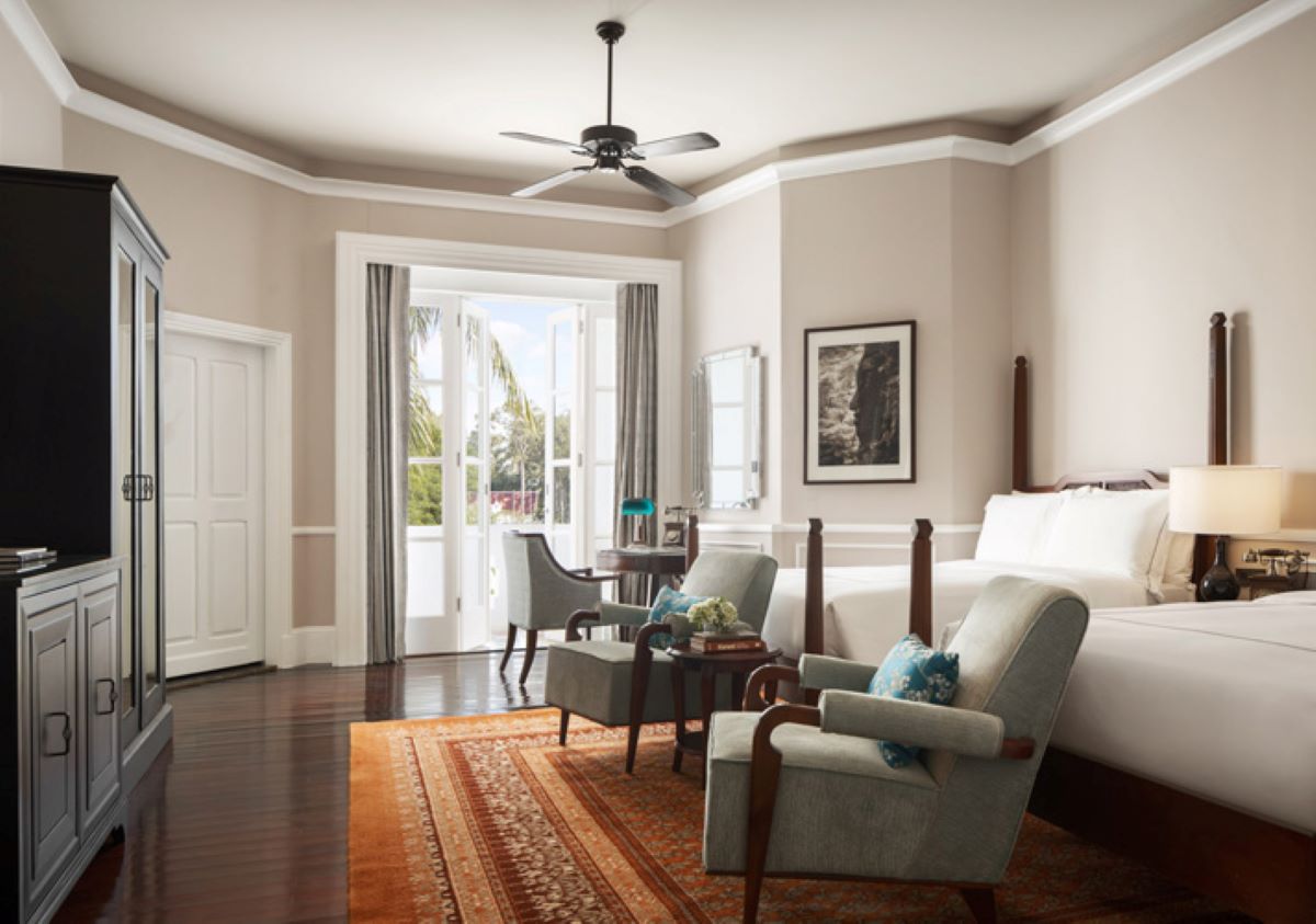 a room with a bed and chairs
