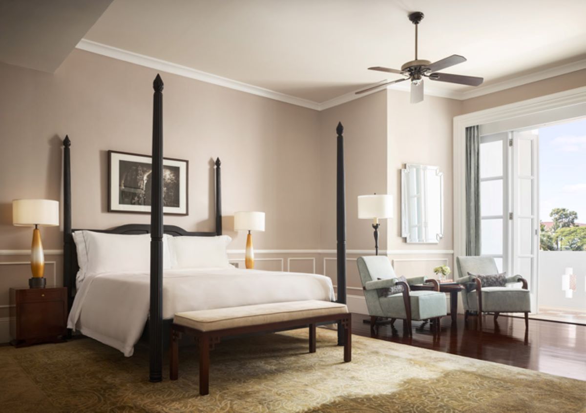 a bedroom with a four poster bed and a fan