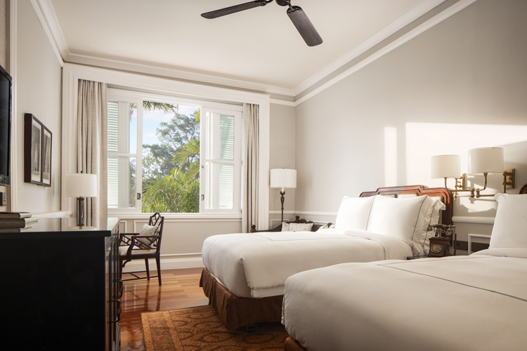 a room with two beds and a fan