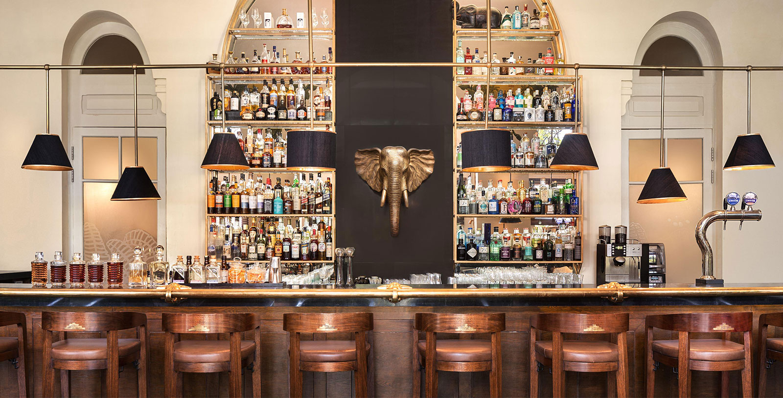 a bar with shelves of liquor and lamps